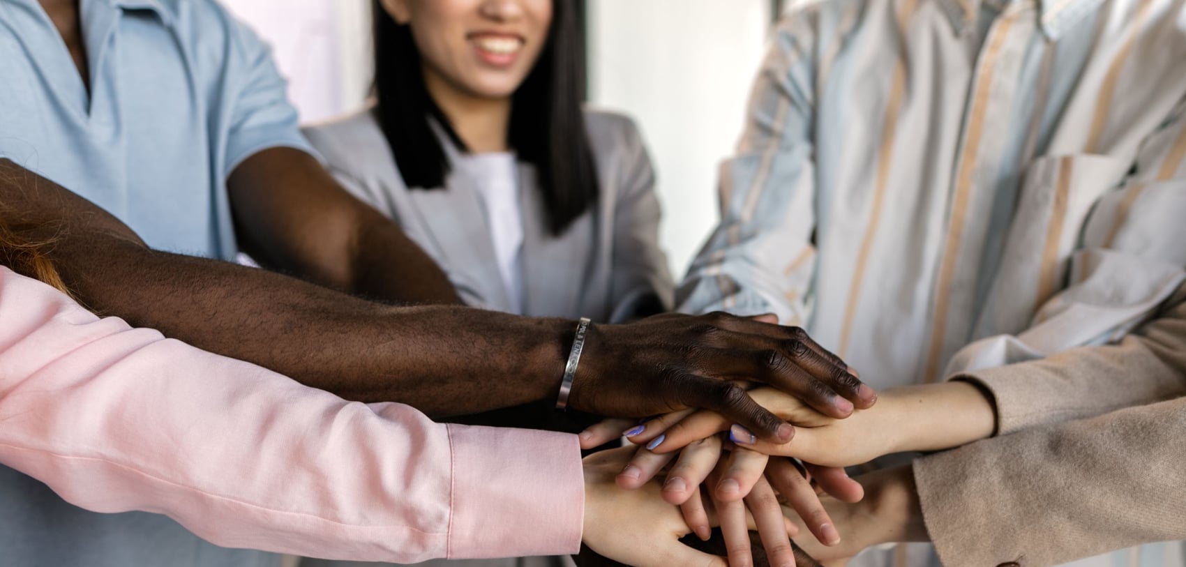 Team members stacking their hands together.
