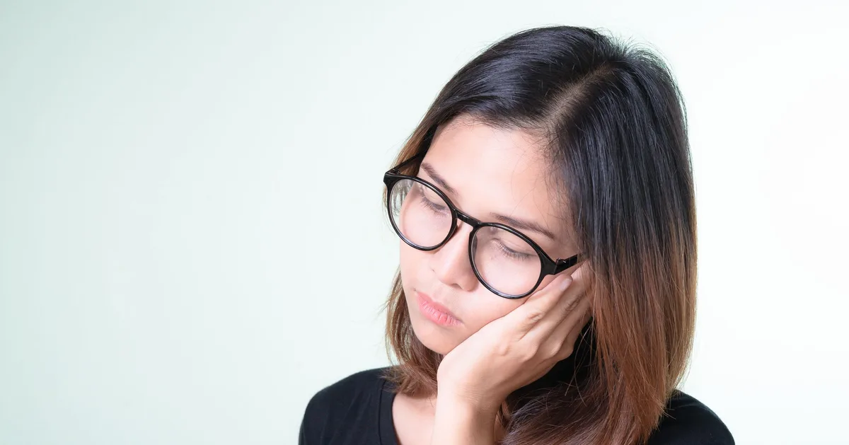 Woman holding her jaw in discomfort.