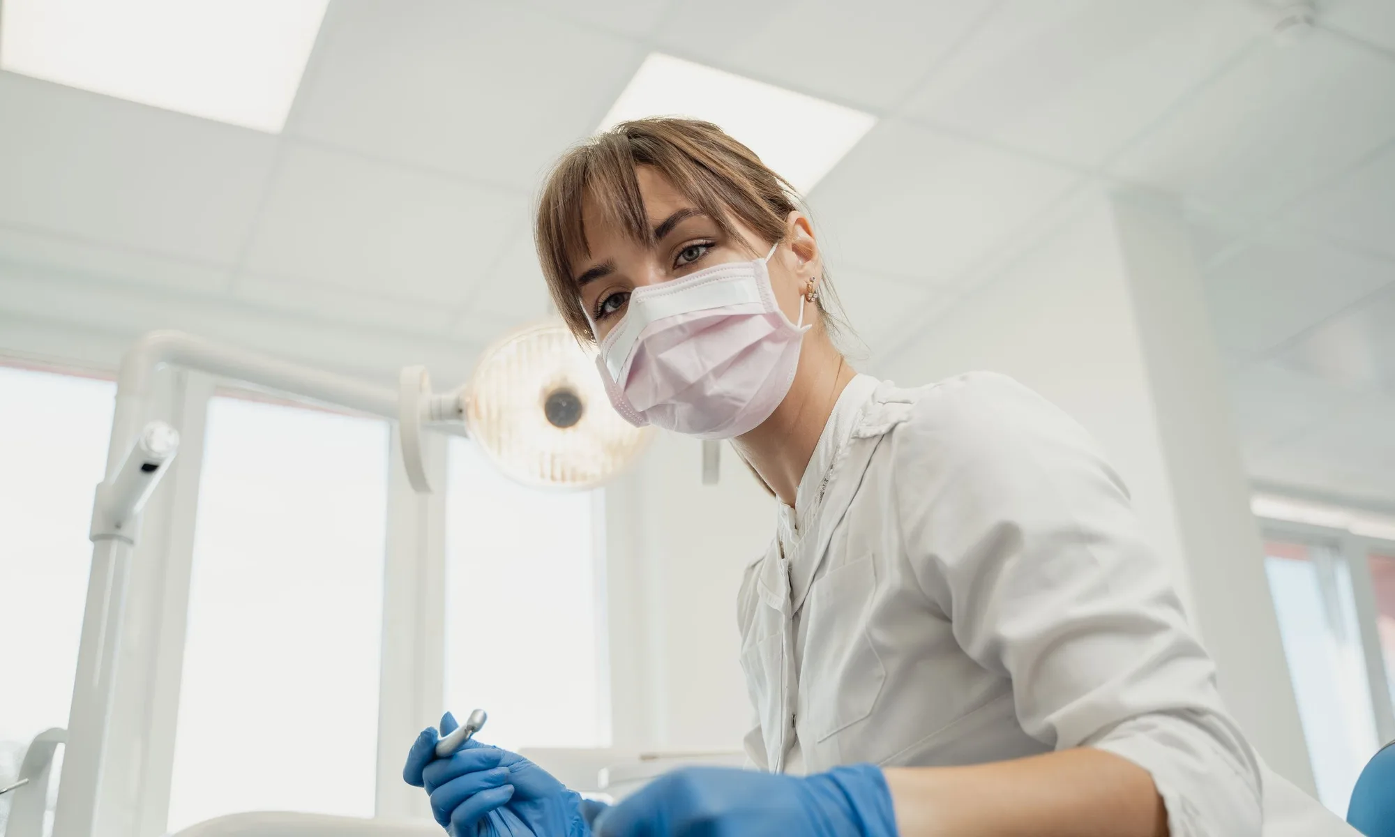 Dentist working with a patient in a bright treatment room.