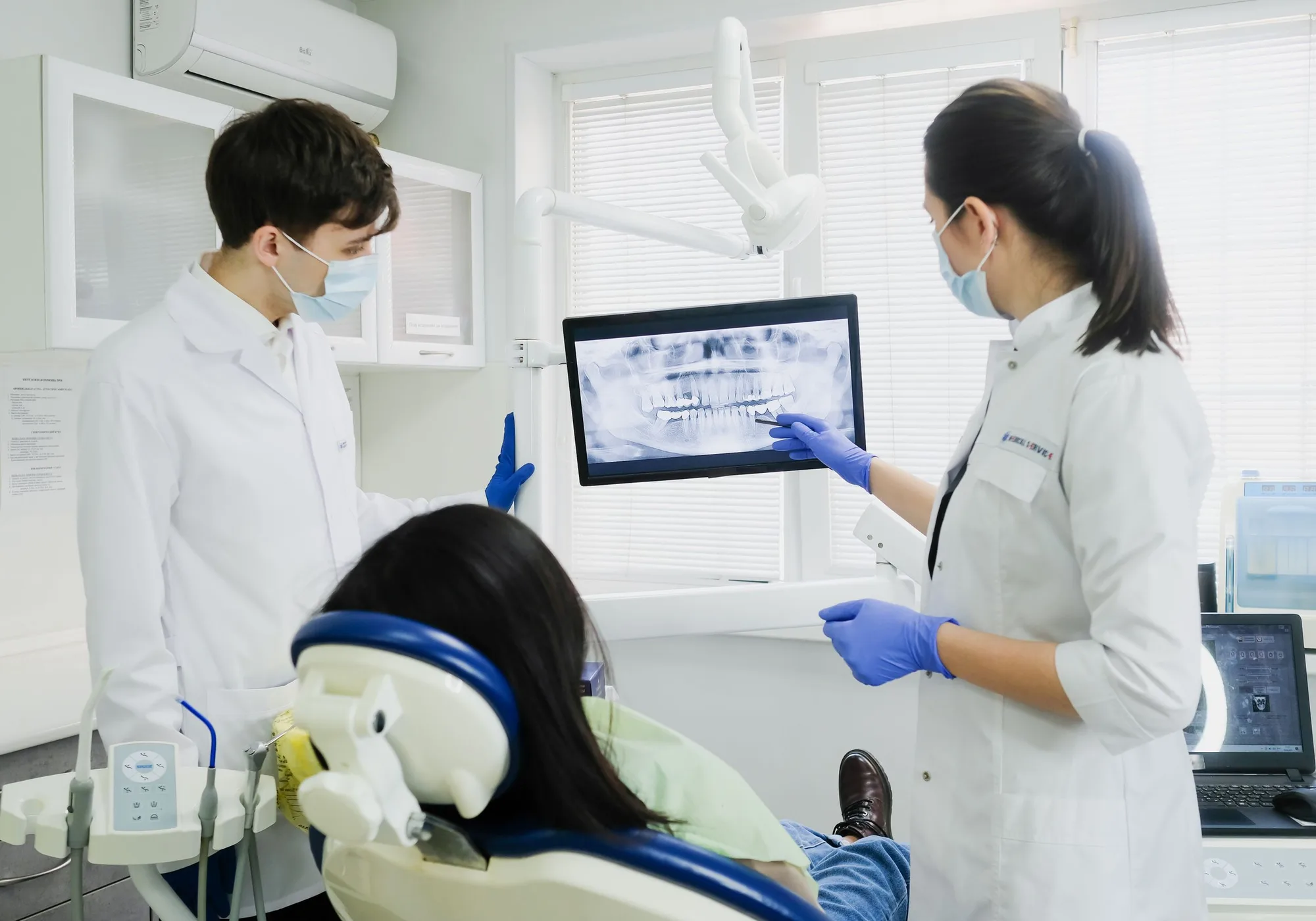 Two dentists looking at an X-ray on a computer.